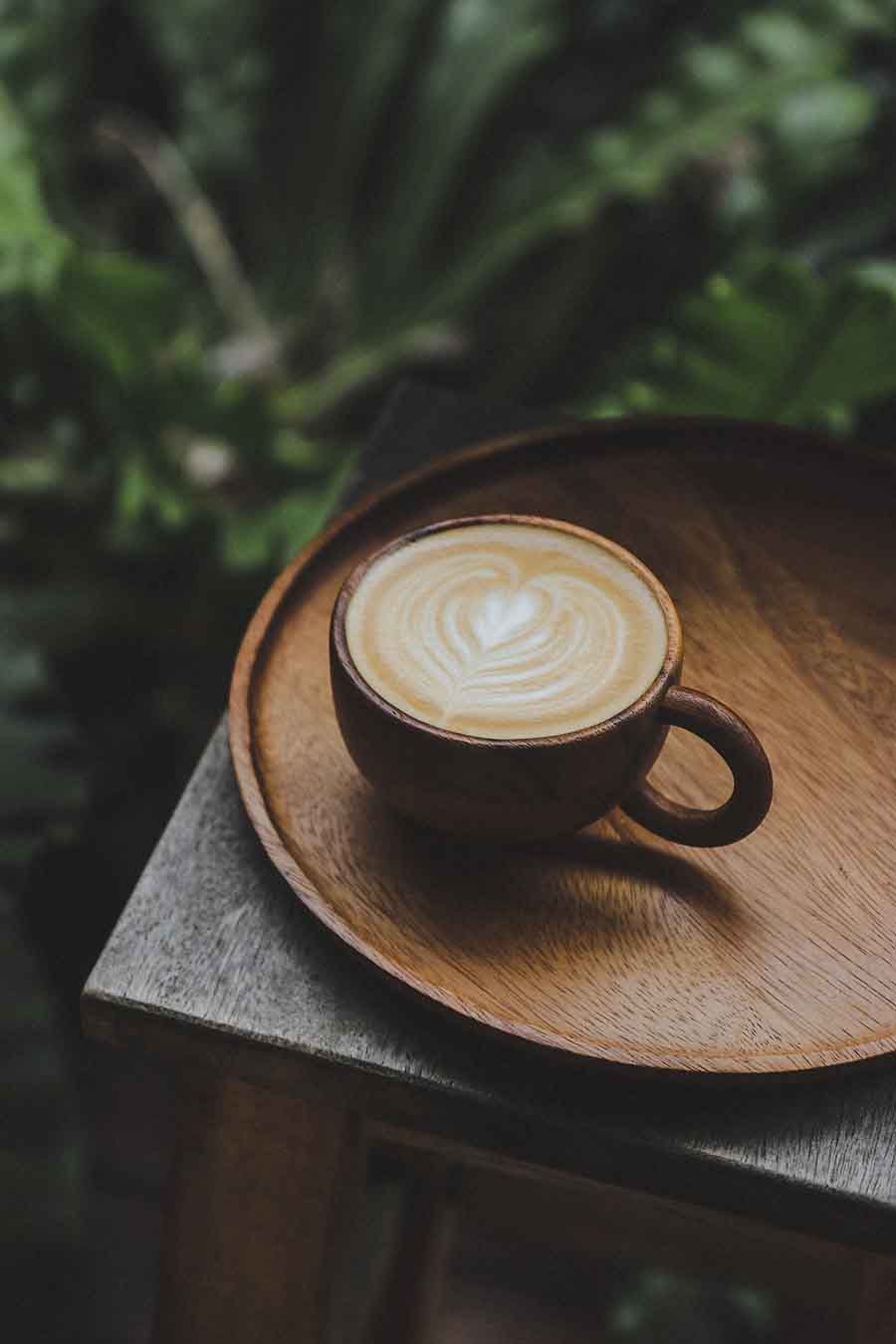 Cappuccino with heart-shaped latte art served in a ceramic mug on a tray