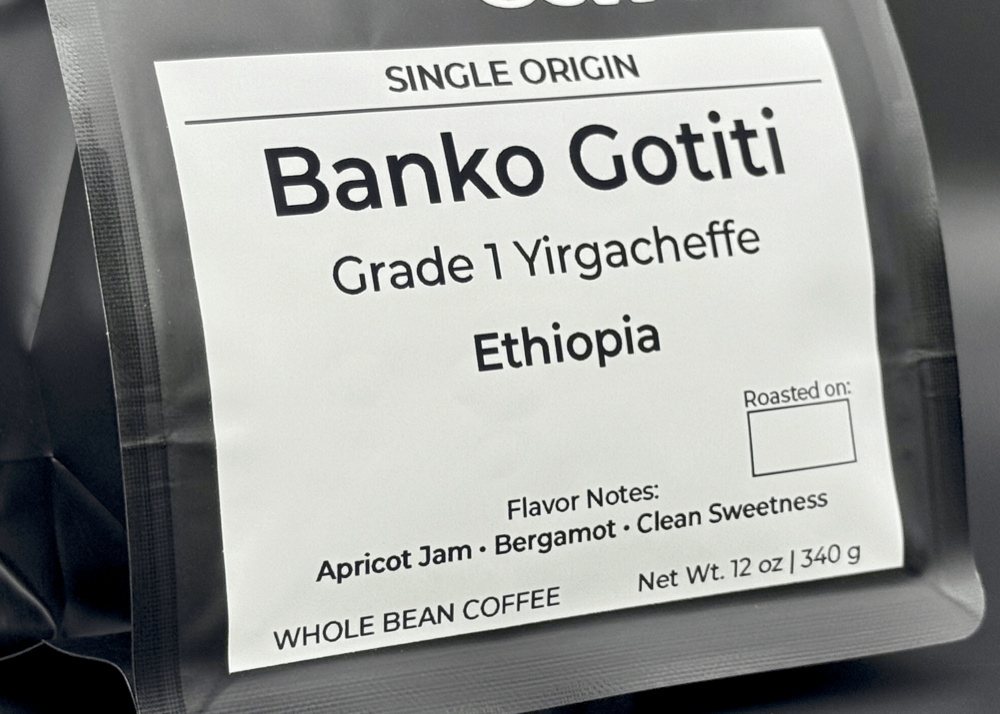 Close-up of white label showing Banko Gotiti Grade 1 Yirgacheffe Ethiopian coffee details, including origin and flavor notes of apricot jam and bergamot