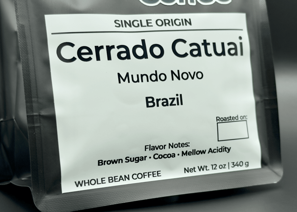 Close-up of white label showing Cerrado Catuai coffee details, featuring Mundo Novo variety from Brazil with brown sugar, cocoa, and mellow acidity notes