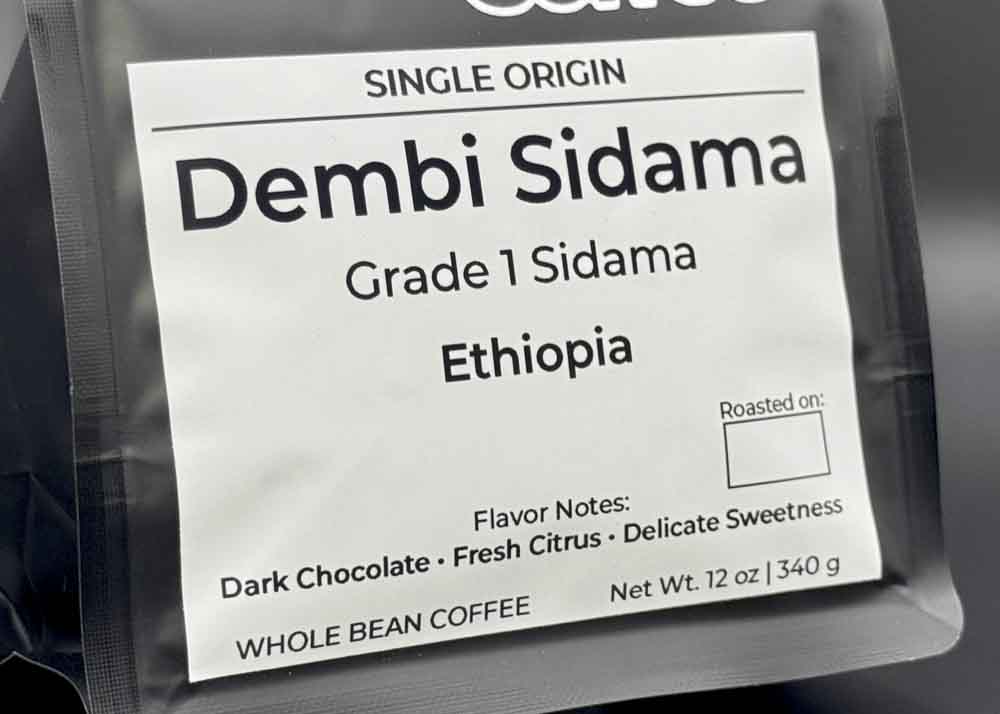 Label close-up of Dembi Sidama coffee bag, tasting notes: dark chocolate, fresh citrus, and delicate sweetness
