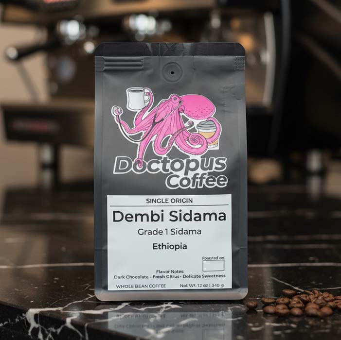 Bag of Dembi Sidama Ethiopian coffee on marble café countertop
