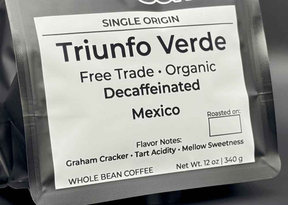 Label close-up of Triunfo Verde decaf coffee bag, tasting notes: graham cracker, tart acidity, and mellow sweetness