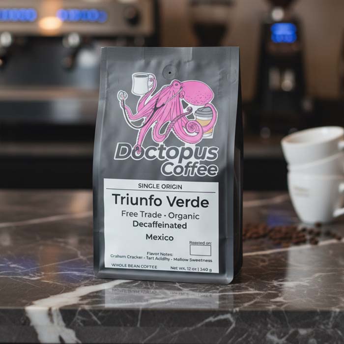 Bag of Triunfo Verde Mexican organic decaf coffee on marble café countertop